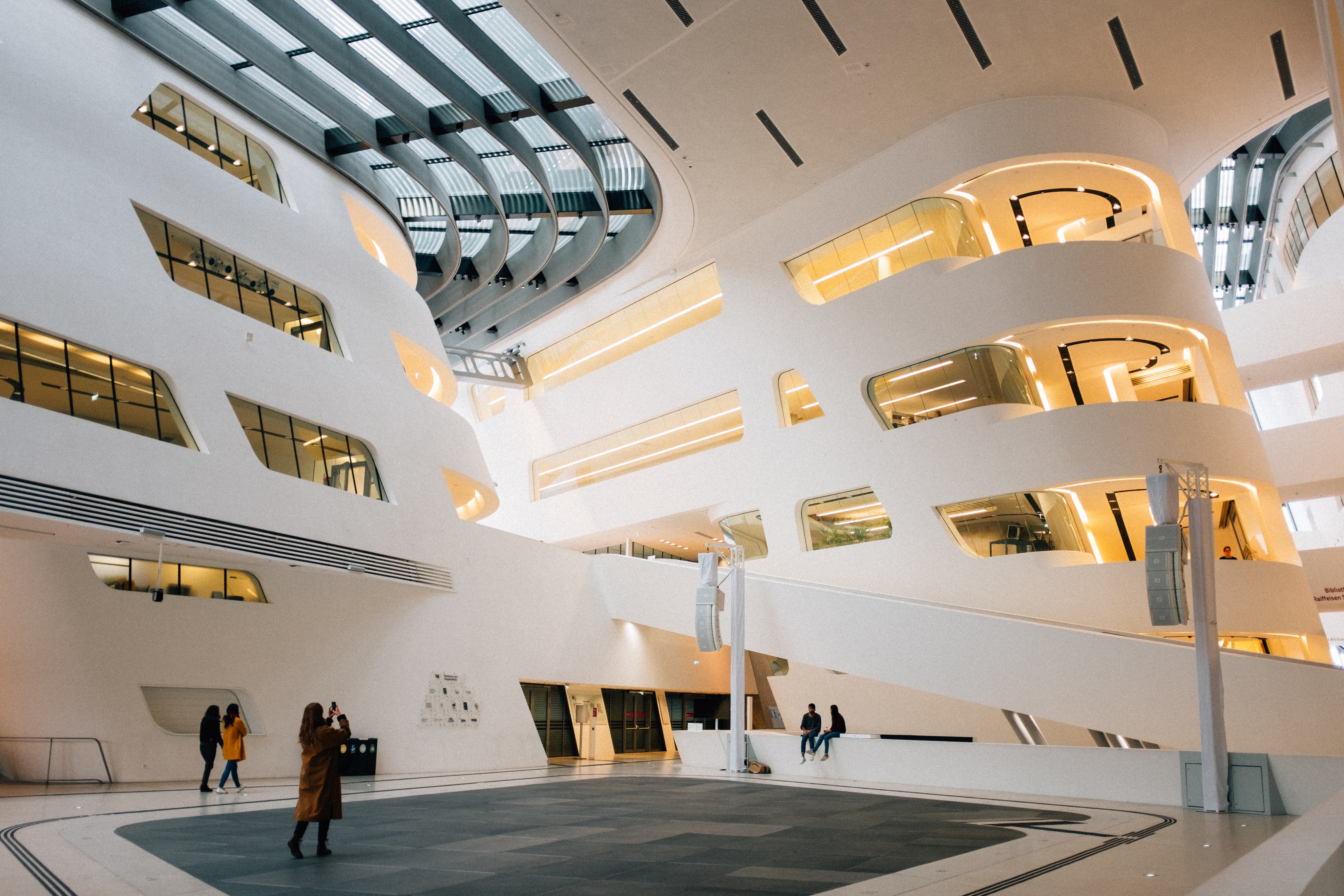 Modern university interior with students studying in a collaborative environment, highlighting spaces conducive to TOEIC test preparation.